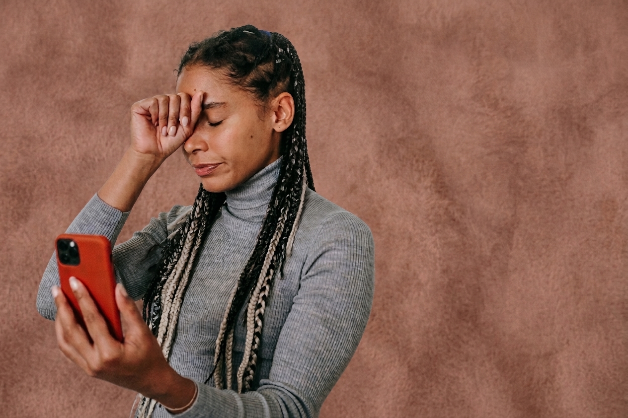 Woman looking stressed while checking her phone