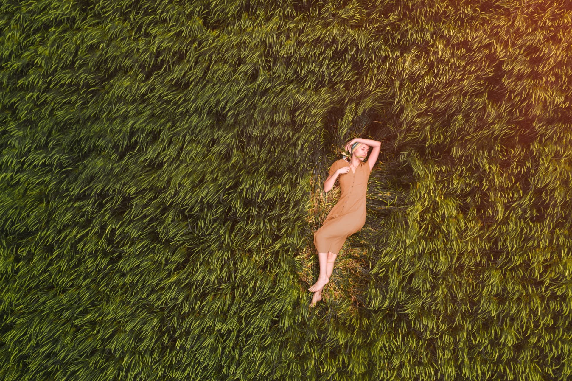 Woman resting in a sunlit field of grass